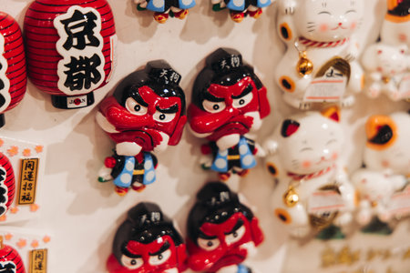 Traditional Japanese tourist souvenirs and gifts from Kyoto, Kansai, Japan, with daruma figures, kitsune fox, tengu mask, refrigerator magnets, toys figurines, key ring keychain, in a local vendor gift shopの写真素材