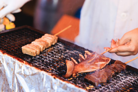 Ikayaki, Grilled roasted Squid with sauce - popular Japanese Street Food, variety of different traditional food snack selection in Tokyo, Japan, street market with local vendor stalls cookingの写真素材