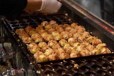 Takoyaki - popular Japanese Street Food, deep-fried dough octopus dumpling balls, variety of different traditional food snack selection in Osaka, Japan, street market with local vendor stalls cookingの写真素材
