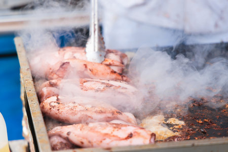 Ikayaki, Grilled roasted Squid with sauce - popular Japanese Street Food, variety of different traditional food snack selection in Tokyo, Japan, street market with local vendor stalls cookingの写真素材