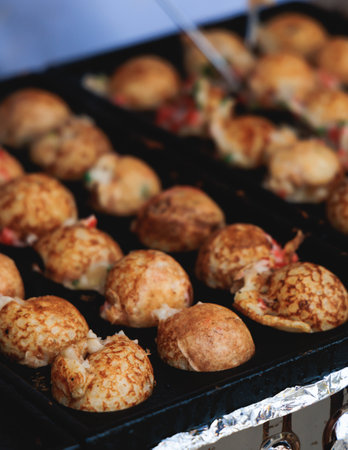 Takoyaki - popular Japanese Street Food, deep-fried dough octopus dumpling balls, variety of different traditional food snack selection in Osaka, Japan, street market with local vendor stalls cookingの写真素材