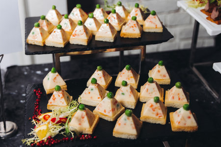Catering table, beautifully decorated banquet with variety of different food snacks appetizers on Christmas birthday corporate party event or wedding celebration, canape, salad, delicatessen settingの写真素材