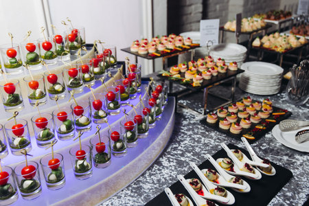 Catering table, beautifully decorated banquet with variety of different food snacks appetizers on...