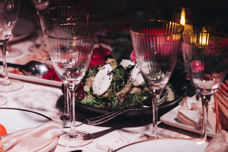 Beautiful table decoration for luxury event in pink and gold, cutlery and tableware, banquet hall arrangement decor, celebration in restaurant with flowers, candles on a wedding reception partyの写真素材