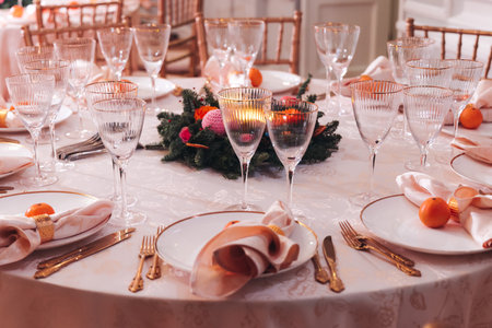 Beautiful table decoration for luxury event in pink and gold, cutlery and tableware, banquet hall arrangement decor, celebration in restaurant with flowers, candles on a wedding reception partyの写真素材
