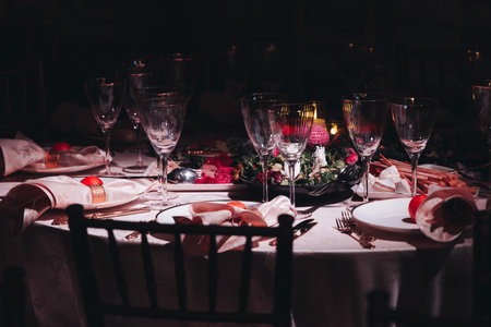 Beautiful table decoration for luxury event in pink and gold, cutlery and tableware, banquet hall arrangement decor, celebration in restaurant with flowers, candles on a wedding reception partyの写真素材