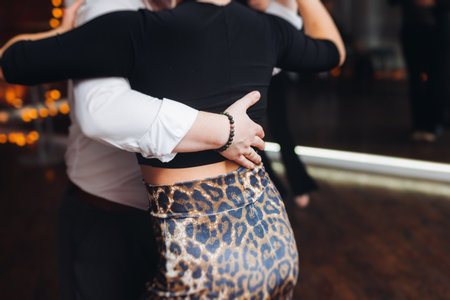 Couples dancing traditional latin argentinian dance milonga in a ballroom, tango salsa bachata lesson in red and purple lights, performance rehearsal, evening dance school class festivalの写真素材