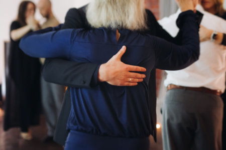 Couples dancing traditional latin argentinian dance milonga in a ballroom, tango salsa bachata kizomba lesson in red and purple lights, performance rehearsal, evening dance school class festivalの写真素材