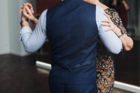 Couples dancing traditional latin argentinian dance milonga in a ballroom, tango salsa bachata kizomba lesson in red and purple lights, performance rehearsal, evening dance school class festivalの写真素材