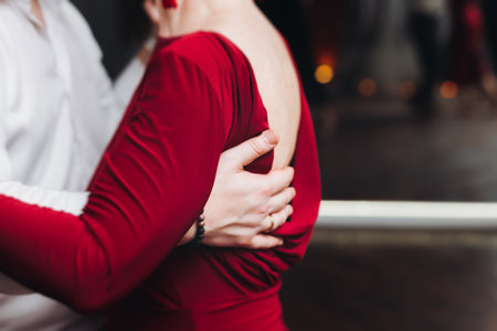 Couples dancing traditional latin argentinian dance milonga in a ballroom, tango salsa bachata lesson in red and purple lights, performance rehearsal, evening dance school class festivalの写真素材
