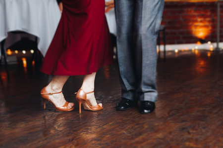Couples dancing traditional latin argentinian dance milonga in the ballroom, tango salsa bachata kizomba lesson in red and purple lights, evening dance school class festivalの写真素材