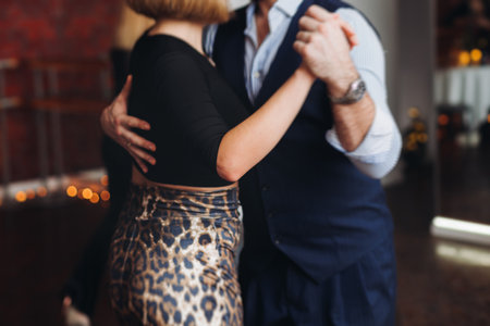Couples dancing traditional latin argentinian dance milonga in a ballroom, tango salsa bachata kizomba lesson in red and purple lights, performance rehearsal, evening dance school class festivalの写真素材