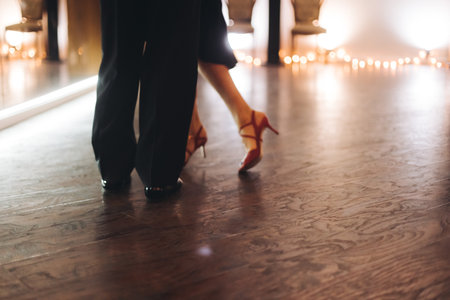 Couples dancing traditional latin argentinian dance milonga in the ballroom, tango salsa bachata kizomba lesson in red and purple lights, evening dance school class festivalの写真素材