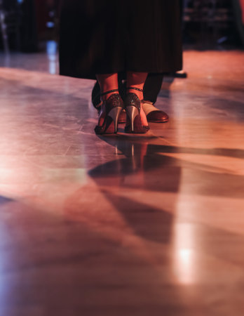 Dancing stiletto shoes of couples dancing traditional latin argentinian dance milonga in the ballroom, tango salsa bachata kizomba lesson in red and purple lights, evening dance school class festivalの写真素材