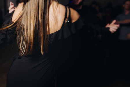 Couples dancing traditional latin argentinian dance milonga in a ballroom, tango salsa bachata kizomba lesson in red and purple lights, performance rehearsal, evening dance school class festivalの写真素材