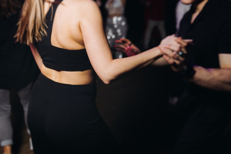 Couples dancing traditional latin argentinian dance milonga in a ballroom, tango salsa bachata kizomba lesson in red and purple lights, performance rehearsal, evening dance school class festivalの写真素材