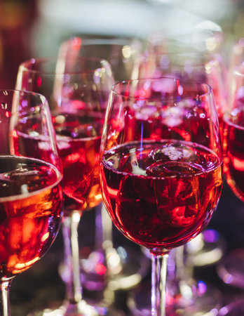 Setting on catering banquet table, row line of orange red colored aperitif cocktails on party, negroni, spritz and others on bar counter, selection of liquor beverages on eventの写真素材