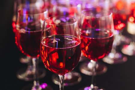 Alcohol setting on catering banquet table, row line of orange red colored aperitif alcohol cocktails on party, negroni, spritz and others on bar counter, selection of liquor beverages on eventの写真素材