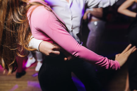 Couples dancing traditional latin argentinian dance milonga in a ballroom, tango salsa bachata kizomba lesson in red and purple lights, performance rehearsal, evening dance school class festivalの写真素材
