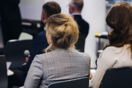 Audience at the modern conference hall listens to panel discussion, people on a congress together listen to speaker on stage at convention, plenary session at business seminar, venue for presentationの写真素材
