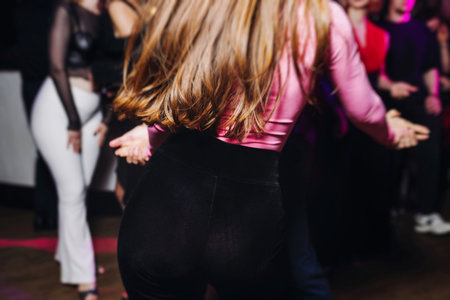 Couples dancing traditional latin argentinian dance milonga in a ballroom, tango salsa bachata kizomba lesson in red and purple lights, performance rehearsal, evening dance school class festivalの写真素材