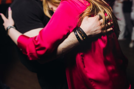 Couples dancing traditional latin argentinian dance milonga in a ballroom, tango salsa bachata kizomba lesson in red and purple lights, performance rehearsal, evening dance school class festivalの写真素材