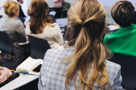 Audience at the modern conference hall listens to panel discussion, people on a congress together listen to speaker on stage at convention, plenary session at business seminar, venue for presentationの写真素材
