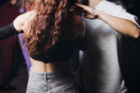 Couples dancing traditional latin argentinian dance milonga in a ballroom, tango salsa bachata kizomba lesson in red and purple lights, performance rehearsal, evening dance school class festivalの写真素材