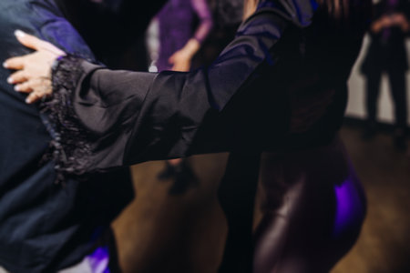 Couples dancing traditional latin argentinian dance milonga in a ballroom, tango salsa bachata kizomba lesson in red and purple lights, performance rehearsal, evening dance school class festivalの写真素材