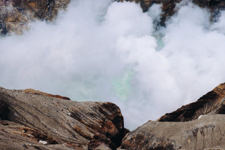 Mount Aso Nakadake volcano crater, Aso-San, caldera, Aso-Kuju National Park hiking, Kyushu island region, Kumamoto prefecture, Japan, eruption with steam and smoke, volcanic desert landscape viewの写真素材