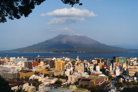View of Kagoshima city, Japan, Kagoshima prefecture, Kyushu island region, with Sakurajima island volcano and Kagoshima bay, seen from Shiroyama park mountain observatory in a spring day with blue skyの写真素材