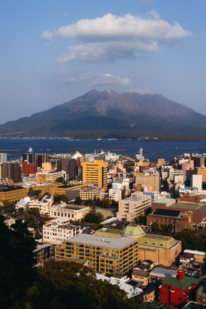 View of Kagoshima city, Japan, Kagoshima prefecture, Kyushu island region, with Sakurajima island volcano and Kagoshima bay, seen from Shiroyama park mountain observatory in a spring day with blue skyの写真素材