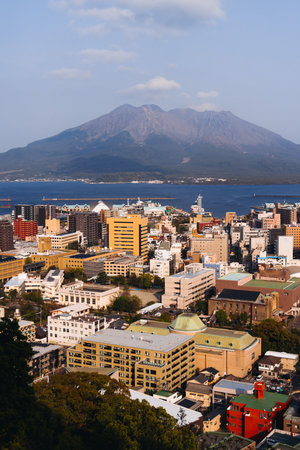 View of Kagoshima city, Japan, Kyushu island region, with Sakurajima volcano and Kagoshima bay, seen from Shiroyama park mountain observatory in a spring day with blue skyの写真素材