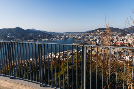 Nagasaki panorama, Japan, beautiful aerial view, with city skyline, port and mountains, seen from Nabekammuri mount, in a spring sunny day with a blue sky, Nagasaki prefecture, Kyushu island regionの写真素材