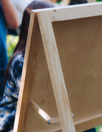 Kids drawing at plein air, group class of talented children with painting easel and wooden canvas during lesson of watercolor painting outdoors in summer, art school class for young teen artistsの写真素材