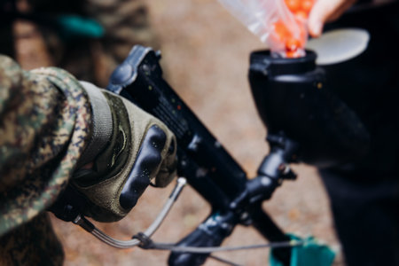 Paintball game, team in camouflage protective uniform with paintball guns and ammunition, strikeball...