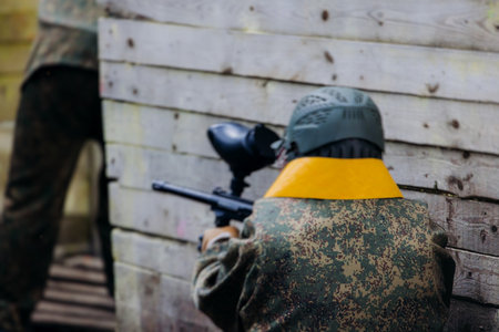 Paintball game, team in camouflage protective uniform with paintball guns and ammunition, strikeball...