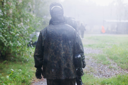 Paintball game, team in camouflage protective uniform with paintball guns and ammunition, strikeball...