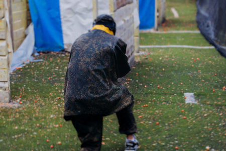 Paintball game, team in camouflage protective uniform with paintball guns and ammunition, strikeball arena battlefield, paintballer aiming and shooting at opponents, airsoft players match tournamentの写真素材