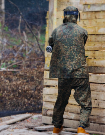 Paintball game, team in camouflage protective uniform with paintball guns and ammunition, strikeball...