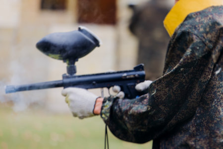 Paintball game, team in camouflage protective uniform with paintball guns and ammunition, strikeball...
