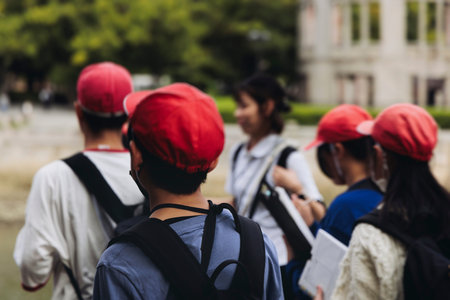 Group of school children students outdoor excursion, guided tour in the city with guide, docent with...