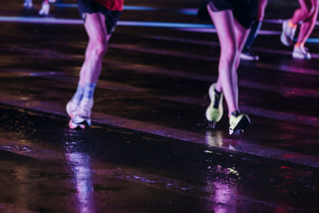 Night marathon runners crowd in the rain, sportsmen participants start running the half-marathon in...