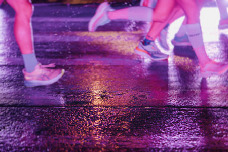 Night marathon runners crowd in the rain, sportsmen participants start running the half-marathon in...