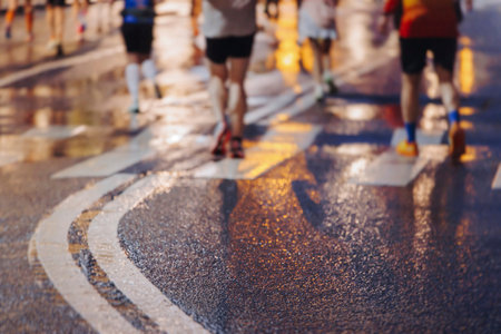 Night marathon runners crowd in the rain, sportsmen participants start running the half-marathon in...
