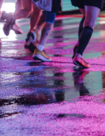 Night marathon runners crowd in the rain, sportsmen participants start running the half-marathon in...