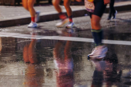 Night marathon runners crowd in the rain, sportsmen participants start running the half-marathon in...