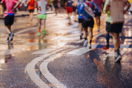 Night marathon runners crowd in the rain, sportsmen participants start running the half-marathon in...