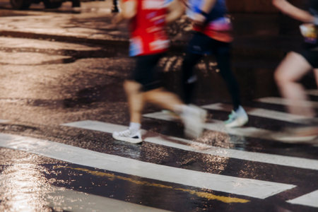 Night marathon runners crowd in the rain, sportsmen participants start running the half-marathon in...