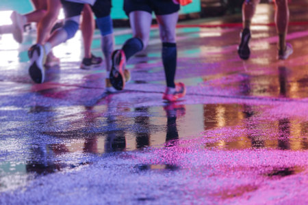 Night marathon runners crowd in the rain, sportsmen participants start running the half-marathon in...